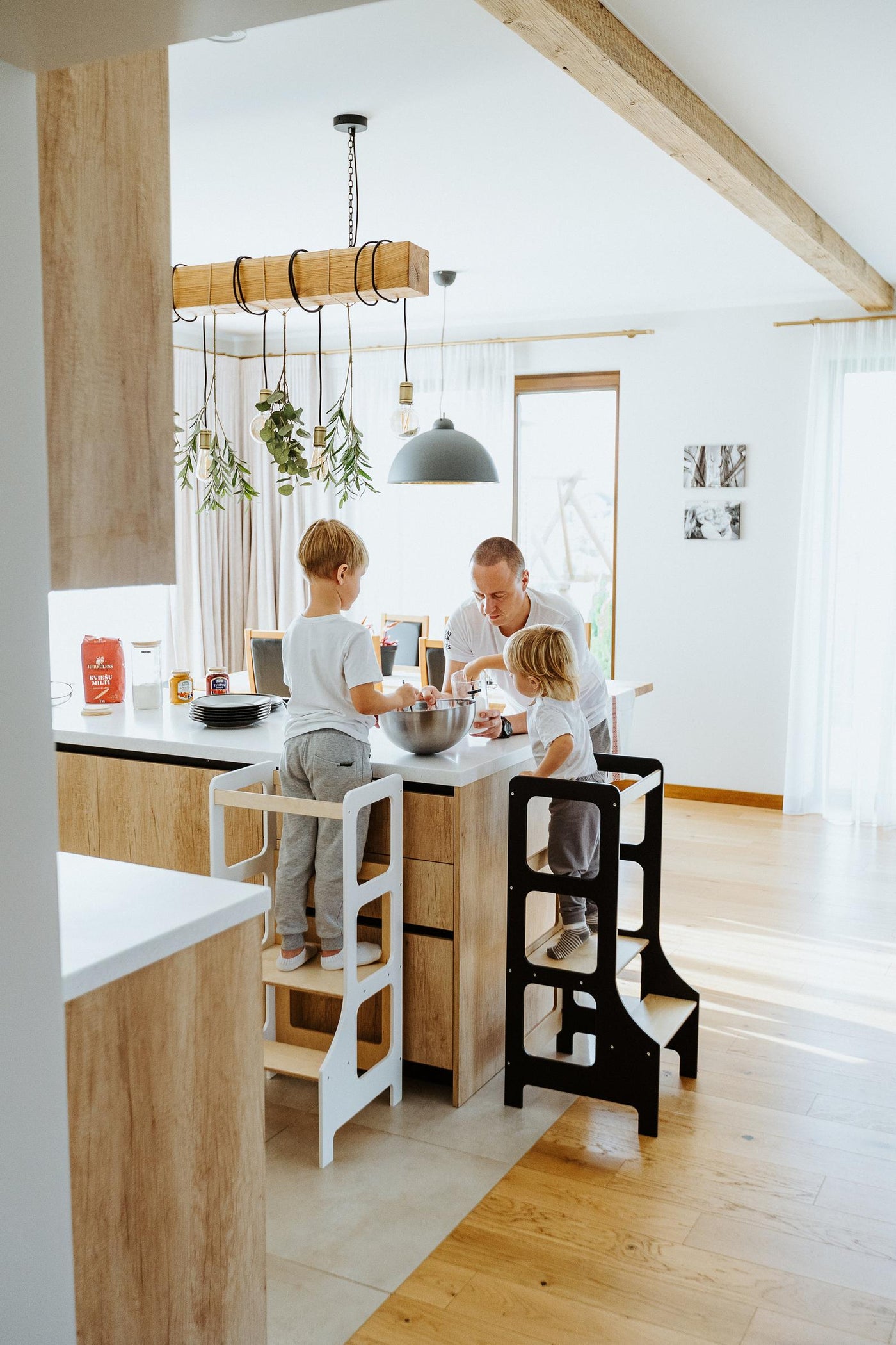 Children on Learning Towers with Father in Kitchen