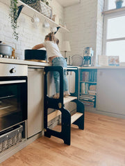 Adjustable-height toddler kitchen helper stool with secure side panels.