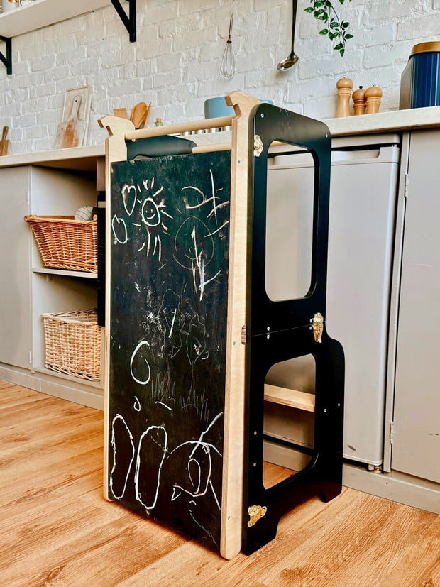 Montessori-inspired learning tower in natural wood, white, and black finishes.