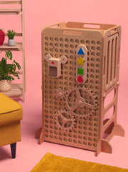 Tinker Tower in Natural Wood with pink background and soft furnishings