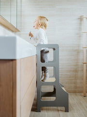 grey learning tower with child brushing teeth