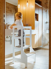 white learning tower with child in bathroom